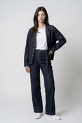 Front view of The Stitchline Denim Jacket, model with hand on hip, styled with indigo jeans