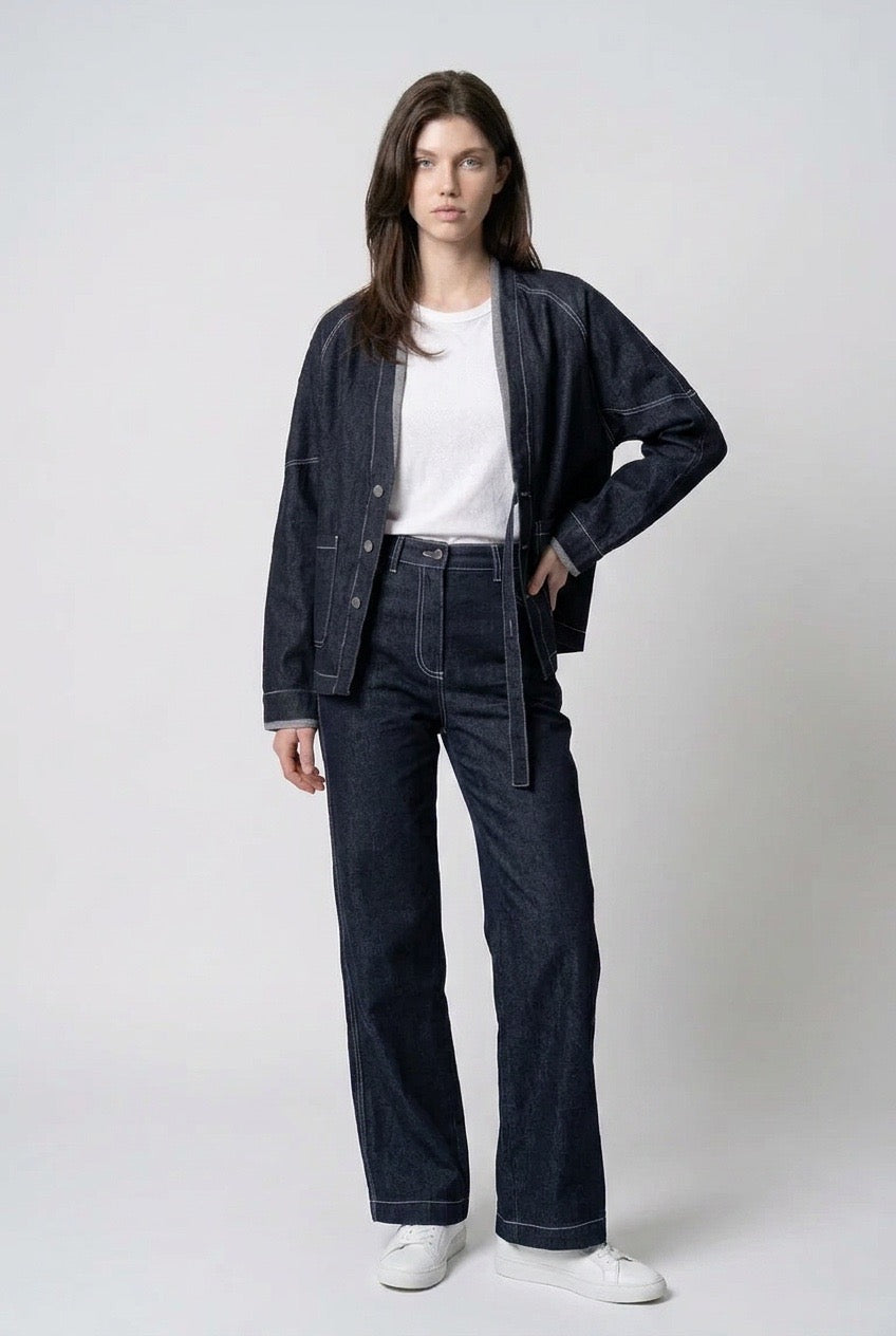 Front view of The Stitchline Denim Jacket, model with hand on hip, styled with indigo jeans