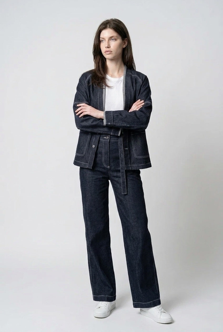 Model with arms crossed wearing the oversized collarless indigo denim jacket