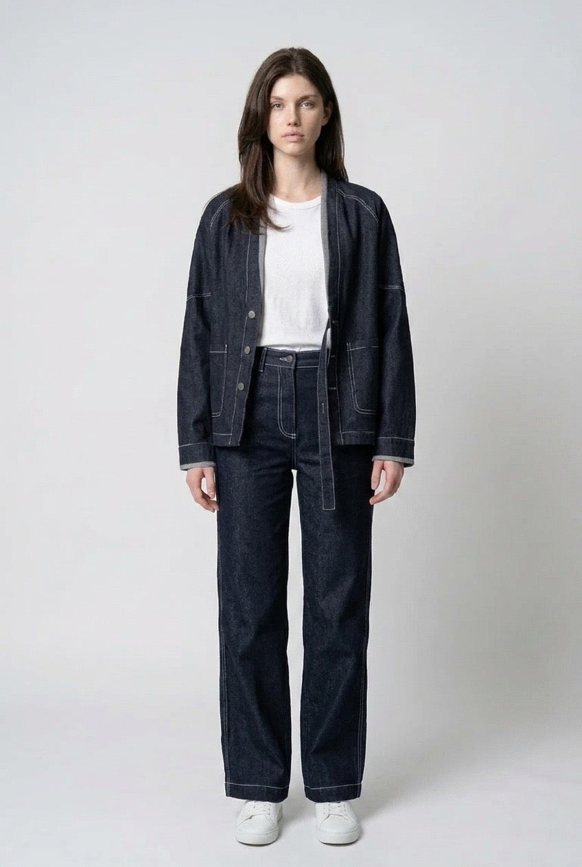 Full-length front view of the collarless denim jacket worn open over a white tee