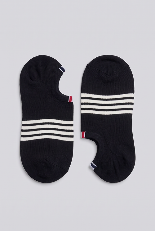 Pair of black low-cut socks with four white stripes and a red, white and blue heel tab, laid flat on light grey