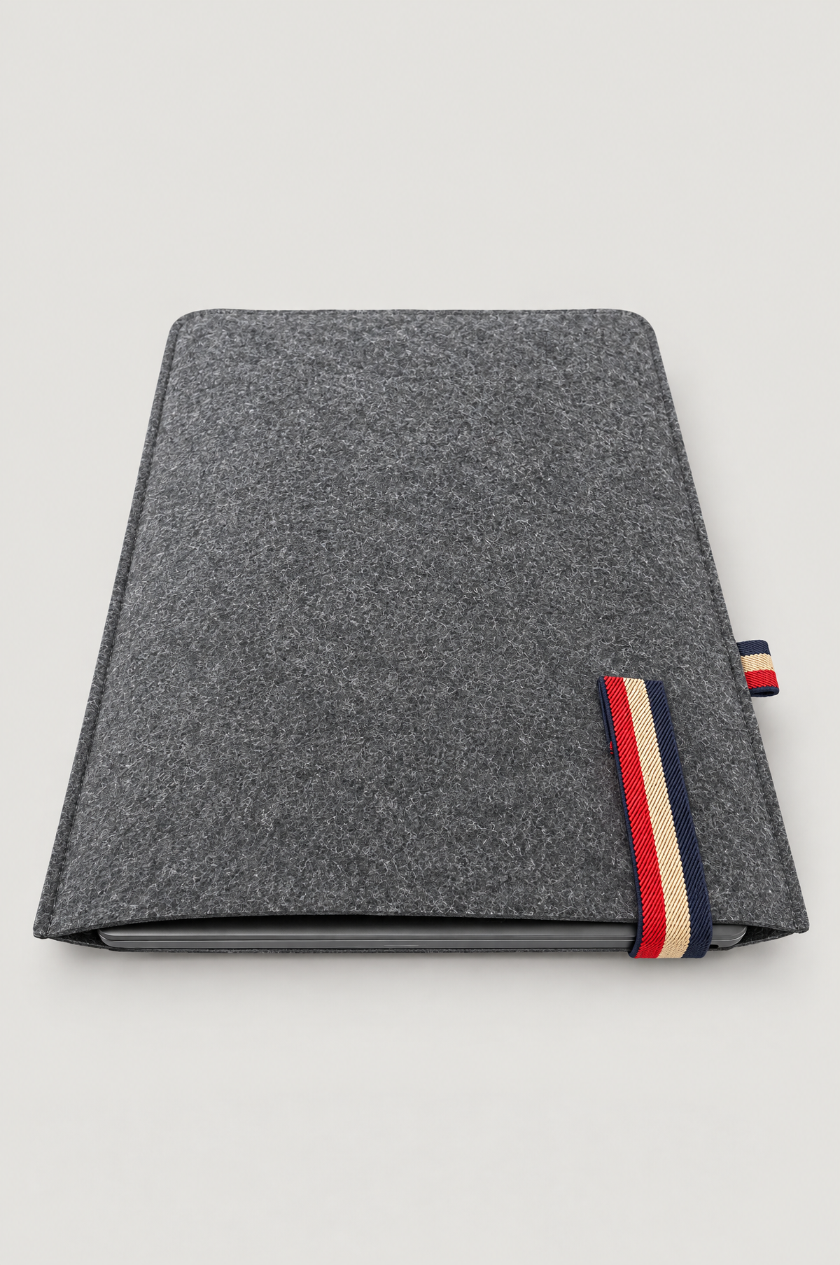 Charcoal felt laptop sleeve with laptop inside and red, beige and navy striped elastic band (laptop not included)