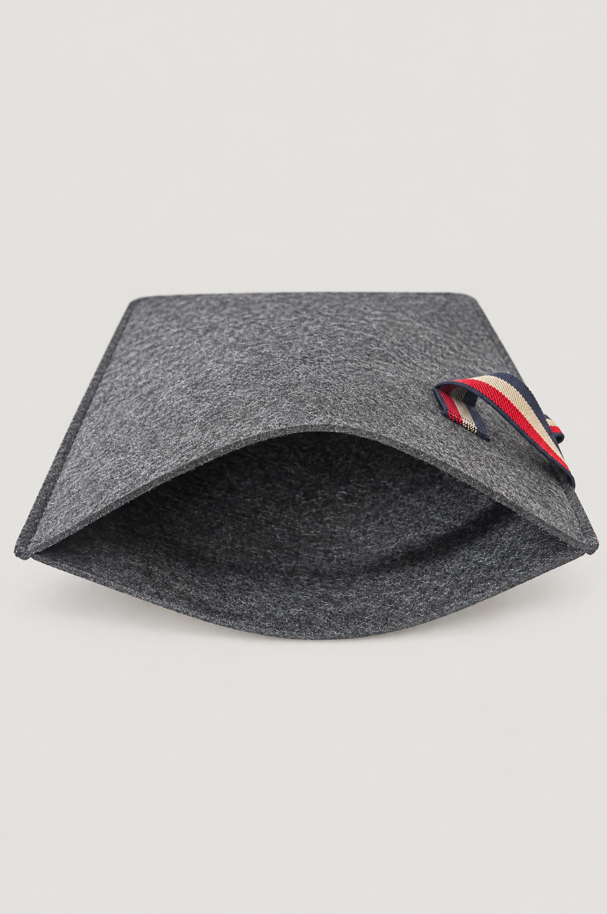 Charcoal felt laptop sleeve shown open with striped elastic loop
